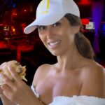 Mujer disfrutando de una hamburguesa en el ambiente exclusivo del club swinger Open-Minded en Valencia.