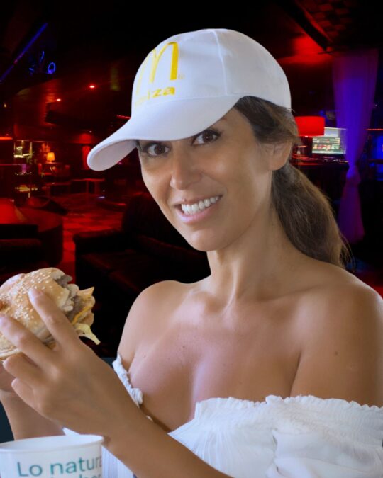 Mujer disfrutando de una hamburguesa en el ambiente exclusivo del club swinger Open-Minded en Valencia.
