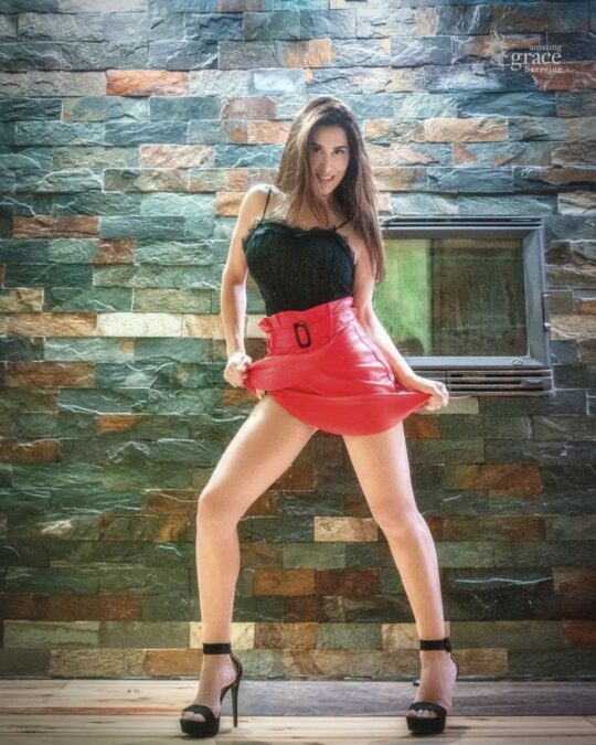 Mujer posando con falda roja en el único club swinger auténtico de Valencia, Open-Minded.club, para la temática “Some Like It Hot”.