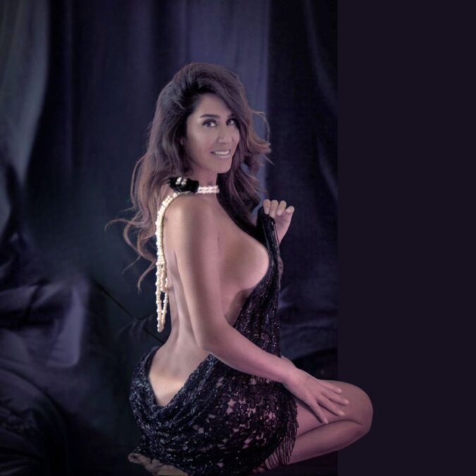 Mujer en un elegante atuendo oscuro, posando en un ambiente íntimo y sensual de OPEN-MINDED Club, el único club swinger auténtico de Valencia.
