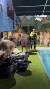 Fotograma del vídeo de Ecuadorplay: un agente de control junto a la piscina del local, con las personas asistentes pixeladas